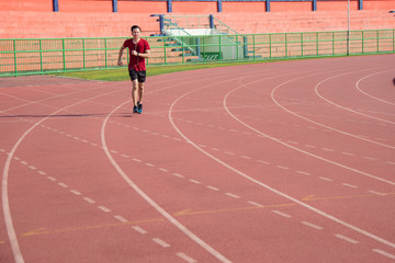 Fototapeta premium Young asian sporty man running in sport complex center