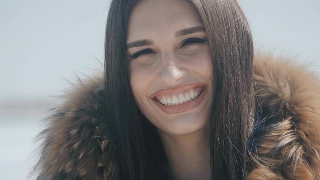 portrait of young Pretty beautiful brunette woman smiling at winter snowy background