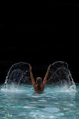 Woman at the swimming pool splattering water