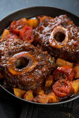 Close-up of ossobuco stewed with oranges and tomatoes, vertical shot, selective focus