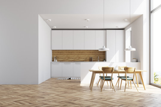 White and wooden kitchen with a table, wall