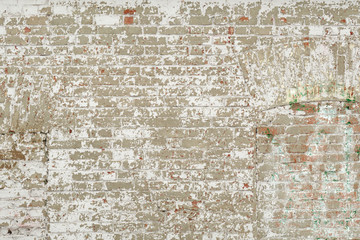 Old red brick wall with white paint background texture. The door and window openings are closed with bricks, that have been blocked down.