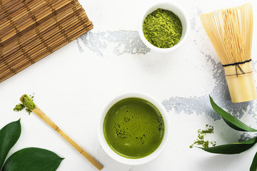 Green matcha tea drink and tea accessories on white background