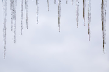 Frozen icicles hanging with sky background and copy space 2