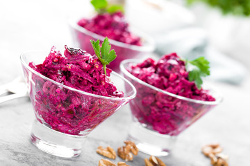 Beet salad. Salad of boiled beet. Beetroot salad with prune, walnuts and sour cream on white background