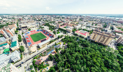 Aerial city view with crossroads and roads, houses, buildings, parks and parking lots, bridges. Helicopter drone shot. Wide Panoramic image.