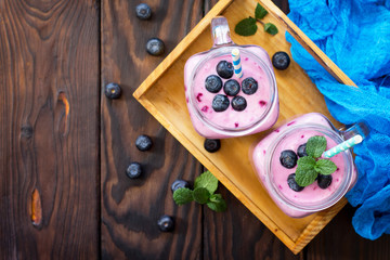 Mason jar mugs with fresh berry cocktails blueberry. The concept of proper nutrition and health or detoxification. Copy space, top view of a flat background. © elena_hramowa