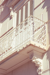 Vintage forge white balcony in Europe.Card from France. Decorative classical facade.