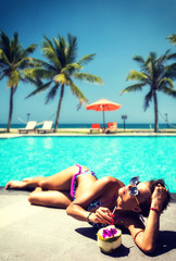 Woman at the swimming pool at the tropical summer resort