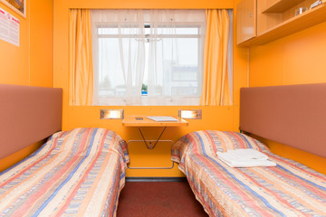Interior of the double living cabin on a cruise ship - with beds and window