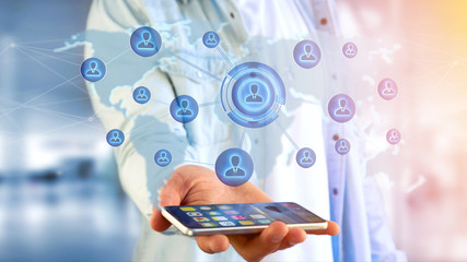 Businessman using a smartphone with a Network over a connected world map - 3d render