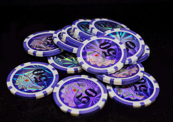 Many game chips with different denominations, different colors are on the table.  Passion, game, poker, casino.