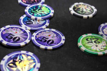 Many game chips with different denominations, lie in the hand.  Passion, game, poker, casino.