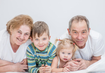 portrait of grandparents with grandchildren on the bed