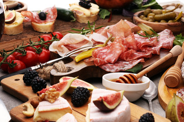 Italian antipasti wine snacks set. Cheese variety, Mediterranean olives, pickles, Prosciutto di Parma and salami