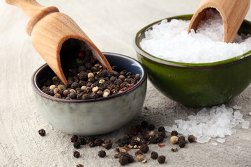 rough salt and mixed peppercorns on wooden shovels