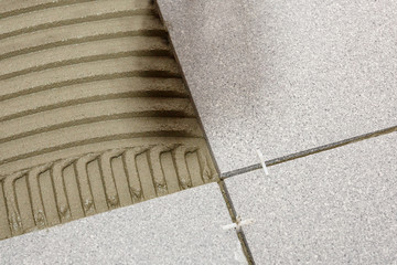 Fragment of the floor, in the process of laying ceramic tiles, close-up.