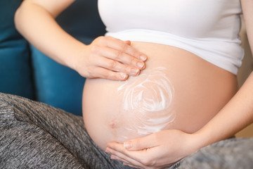 Fototapeta na wymiar pregnant woman applying cream on her belly