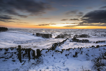 Stunning Winter sunset over snow covered Winter landscape in Peak District