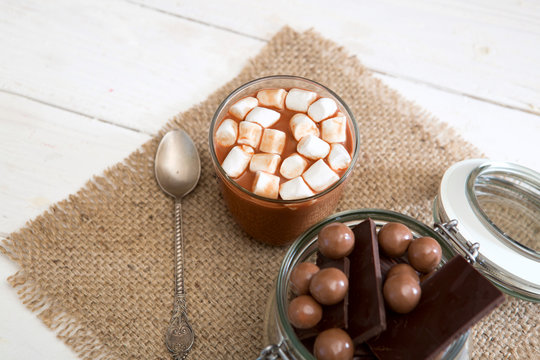 Chocolate shake with marshmallows on white wooden table