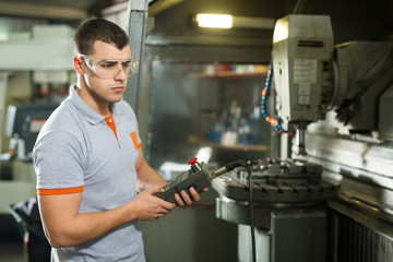 Metal Worker Working On CNC Machine In Factory