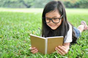 Education Concepts. The girl is reading a book in the garden. Beautiful girl is seriously studying. Beautiful girls are happy learning.