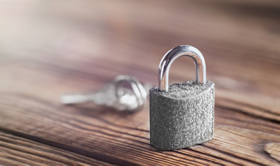 estate concept with symbol of security, lock padlock with key on wooden background.