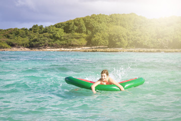 Beautiful teenage girl having fun at the beach with an inflatable toy in the Caribbean sea. Freedom or vacations concept