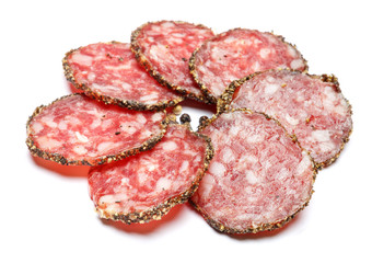Dried organic salami sausage covered with pepper on white background