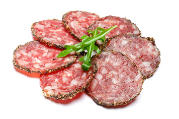 Dried organic salami sausage covered with pepper on white background