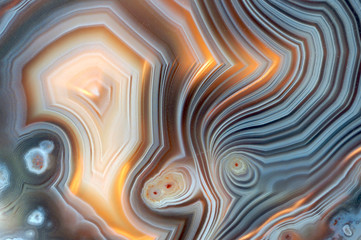Closeup of a banded Agate specimen. The layered structure is formed when a rock cavity or geode is filled with siliceous matter, layer by layer. - obrazy, fototapety, plakaty