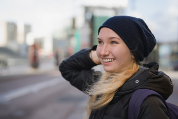 urban portrait of teen girl walking in the city in autumn or spring