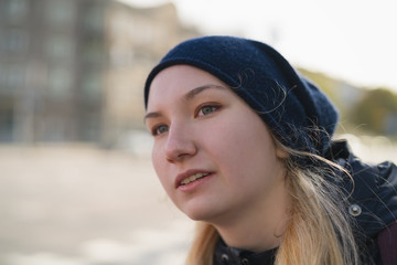 urban portrait of teen girl walking in the city in autumn or spring