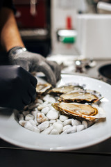 chef puts clean mussels on white stones
