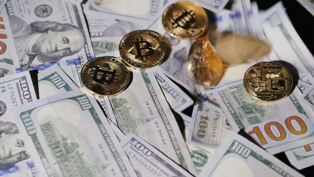 Coins bitkoin fall on American dollars. Crypto currency concept. Slow motion video