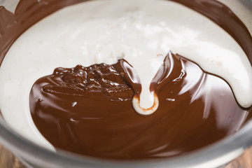 adding cream into melted chocolate