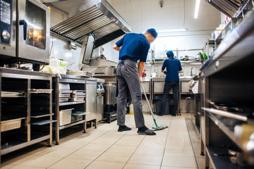 assistant cleans in the kitchen - obrazy, fototapety, plakaty