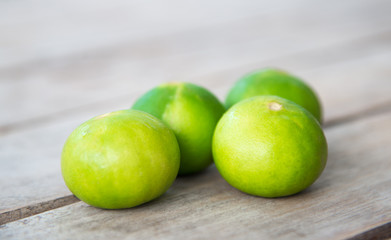 Fresh green lemon on wood table.