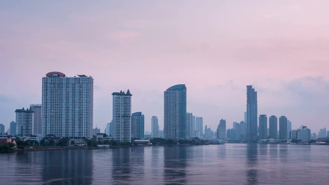 Timelapse - Bangkok city at sunrise with lighted at The downtown area with the Chao Phraya River.