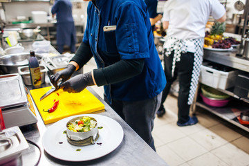 cook cuts chili into salad