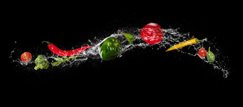 Mix of vegetable in water splash on black background. - Powered by Adobe