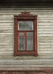 Obraz premium The facade of a wooden building. The window is decorated with wood carvings (carved clypeus). Russian tradition folk style. Front close up view. Chernigov, Ukraine.
