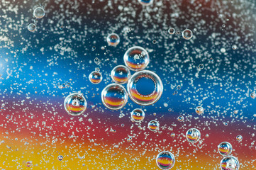 Colorful, abstract oil bubbles on water , focus on the small bubbles, image for background use.