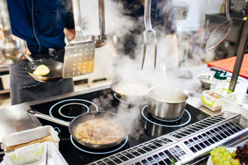 cooks prepare food on the stove