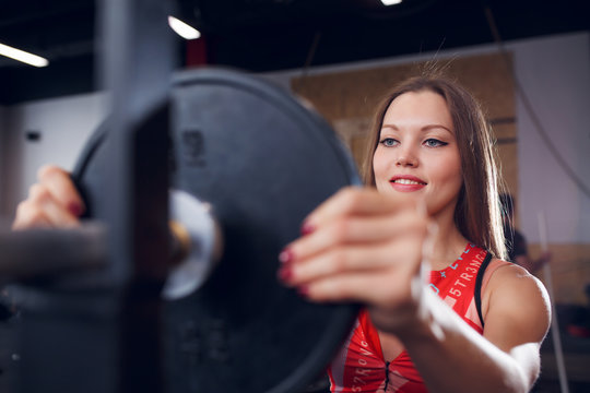 Photo of young athlete in sports clothes with barbell
