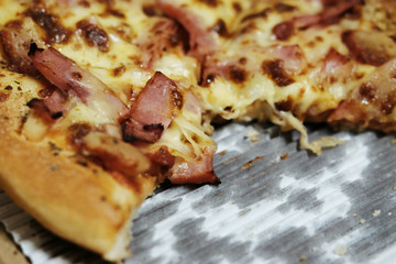 Close-up shot of tasty Italian pizza with ham, and onion in delivery box