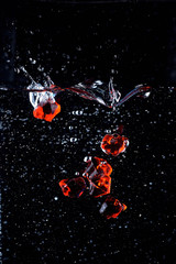 Fototapeta na wymiar drop of red stones into the water with a spray