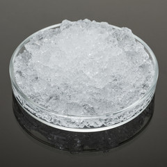 hydro-gel jelly-like, swollen from water, large pieces in glassware on a dark surface