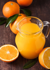 Fototapeta na wymiar Glass jar of raw organic fresh orange juice on wood