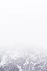Gordijnen Snowfall in the Alps. Snow mountain and fog © Bakulov